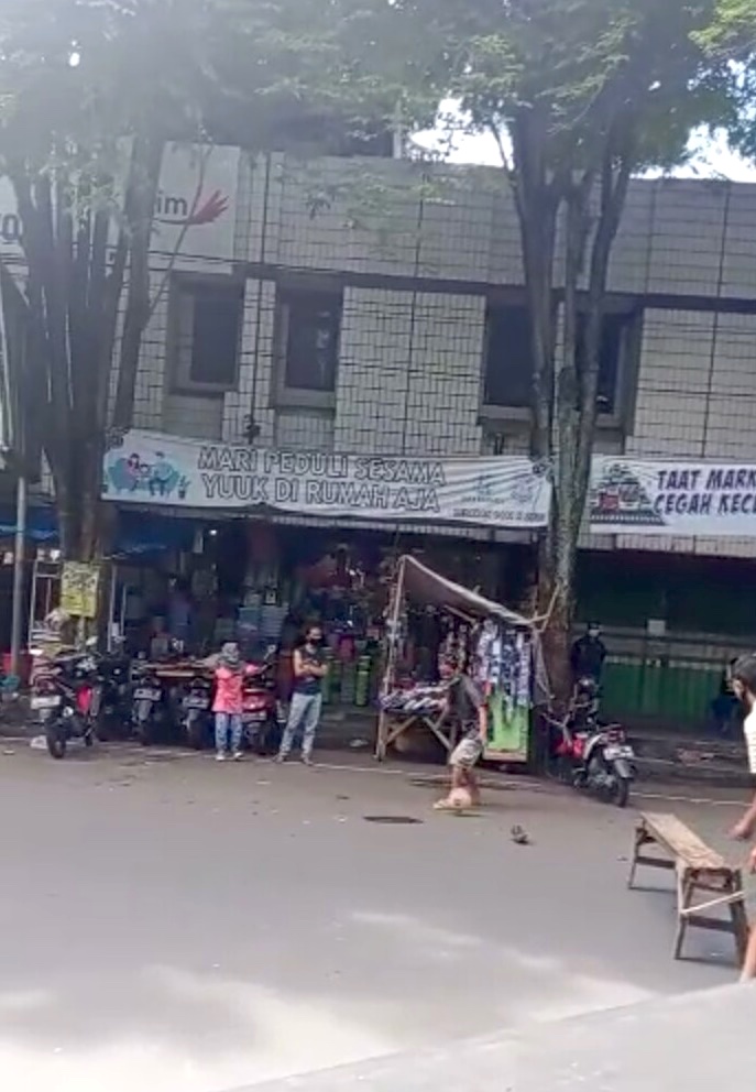 MAIN BOLA: Tangkapan layar dari video warga sekitar Pasar Induk Bondowoso yang sedang bermain bola di tengah jalan ketika jalan ditutup karena PPKM darurat.