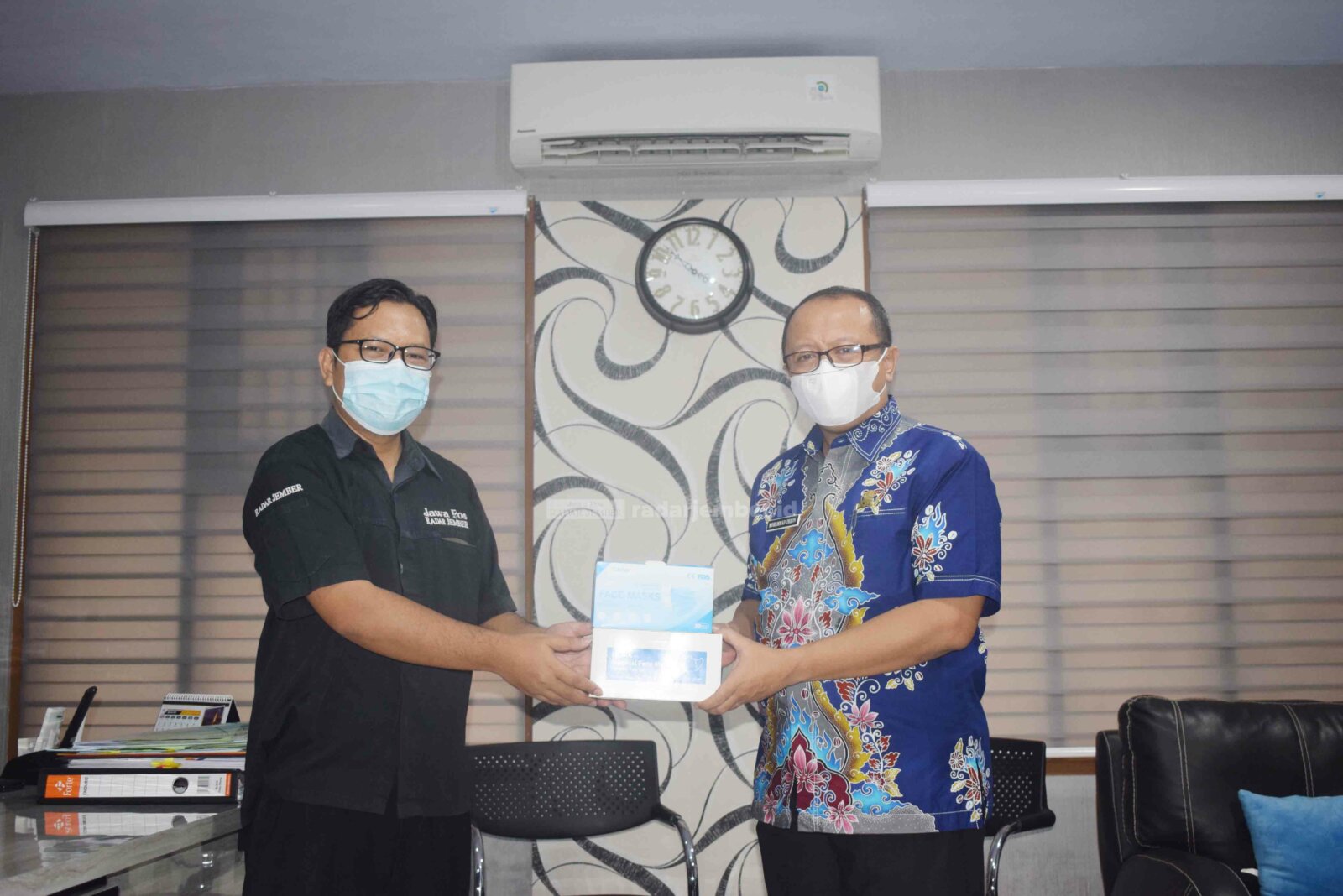 SIMBOLIS: Kepala Dinas Kesehatan Bondowoso Kabupaten Bondowoso Mohammad Imron (kanan) menerima bantuan ribuan masker, kemarin (19/8). APD masker itu diberikan langsung oleh Didik Supriyanto, penanggung jawab Jawa Pos Radar Ijen.