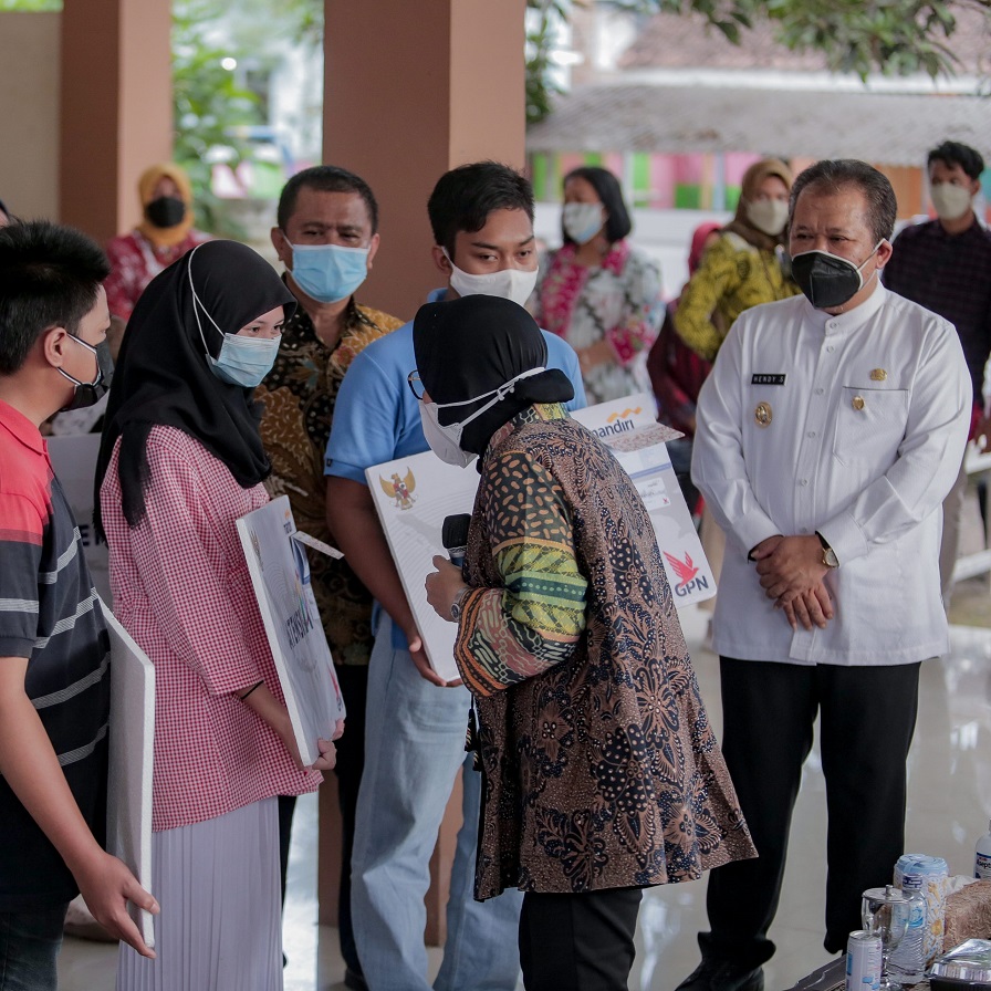 PEDULI: Bupati Jember Hendy Siswanto saat menemani Menteri Sosial Tri Rismaharini ketika memberikan sejumlah bantuan kepada para anak yatim di Kecamatan Rambipuji, akhir pekan lalu.