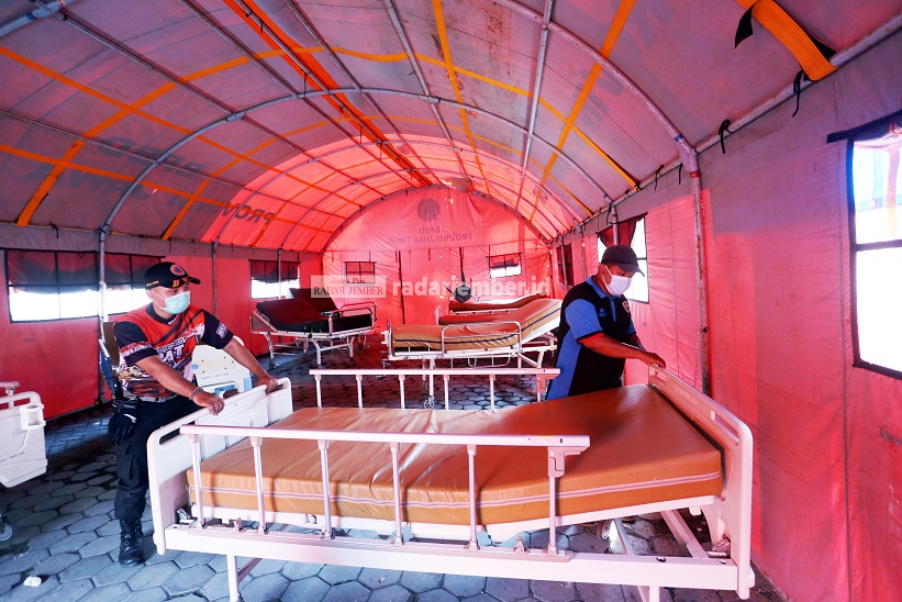 DIBONGKAR: Petugas BPBD Jember bersiap memindahkan tempat tidur di tenda darurat pasien Covid-19 RSD dr Soebandi, kemarin (18/8).