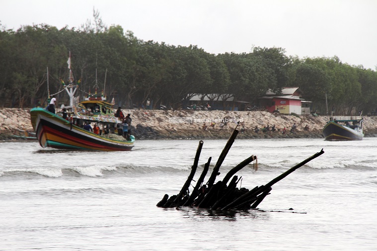 TERONGGOK: Barongan bambu yang terbawa banjir tersangkut di muara Sungai Bedadung. Kondisi ini sangat mengganggu jukung dan perahu milik nelayan yang berangkat maupun pulang melaut.