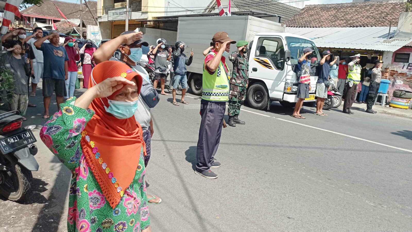 BERI HORMAT: Sejumlah pengguna jalan di persimpangan Klojen, Tompokersan, menghentikan aktivitasnya sementara. Mereka berdiri dan memberi hormat ke bendera merah putih selama tiga menit.