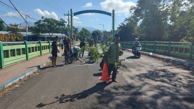 DANA SENDIRI: Sejumlah warga sekitar Jembatan Ki Ronggo menambal jalan menggunakan semen. Aksi itu sebagai bentuk protes kepada pemkab agar jembatan segera diperbaiki.