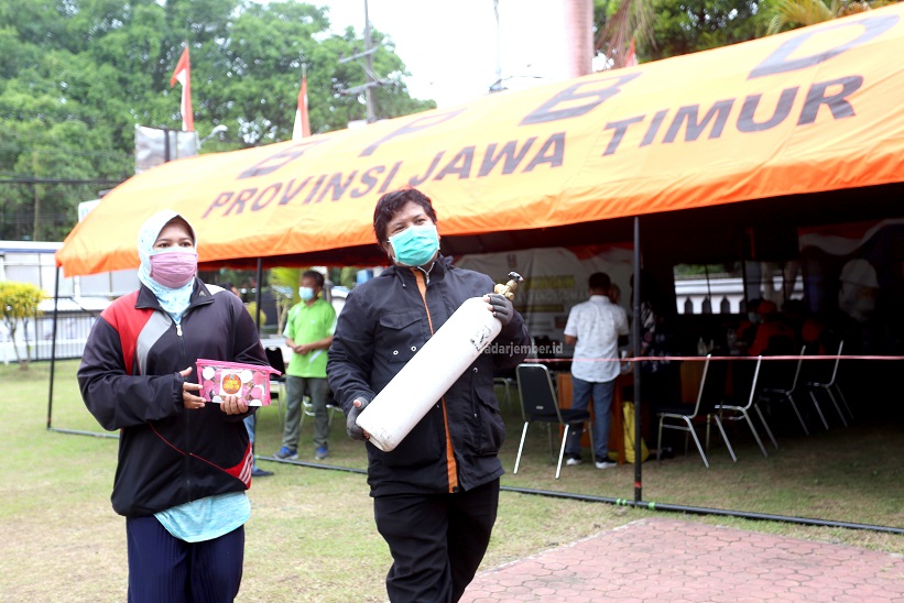PEDULI ISOMAN: M Bahaudin bersama istrinya seusai mendapatkan pengisian oksigen di Kantor Bakorwil Jatim Jalan Kalimantan, kemarin (12/8). Oksigen tersebut akan digunakan saudaranya yang sedang menjalani isoman di rumah.