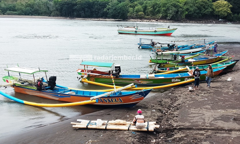 BERJAJAR: Sejumlah perahu nelayan di Kecamatan Puger terparkir di muara Sungai Bedadung akibat debit air berkurang. Para nelayan menunggu sampai air pasang untuk pergi melaut.