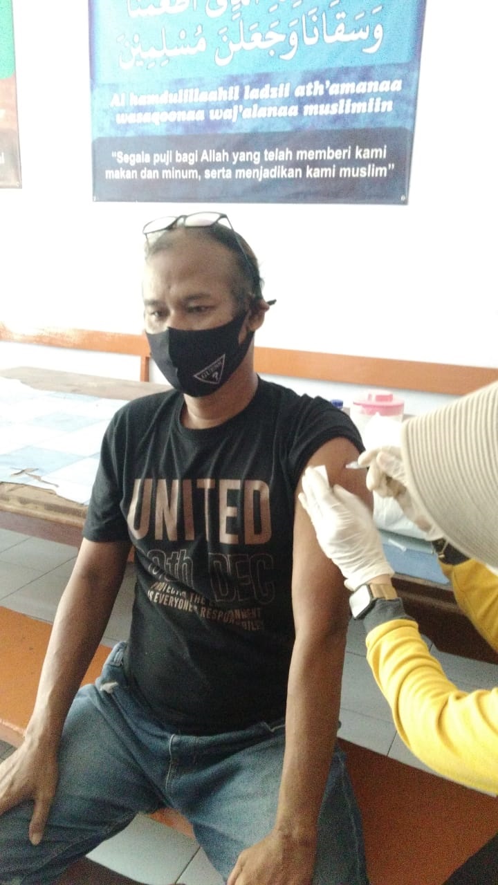 VAKSIN: Salah satu penyandang disabilitas tuli saat menerima vaksin door to door oleh kepolisian dan petugas medis.