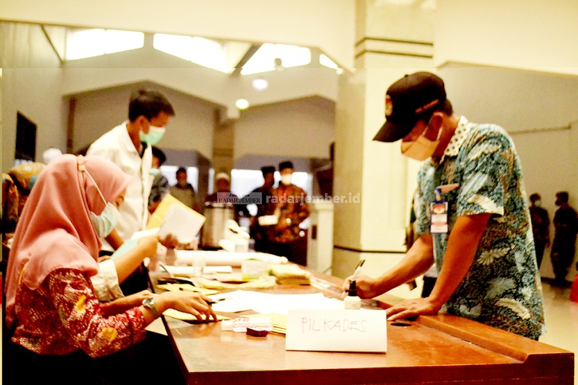 HARUS BERSAING: Salah seorang bacakades mengisi presensi sebelum masuk ke ruang ujian tulis di Aula PB Soedirman Pemkab Jember, kemarin (19/8).