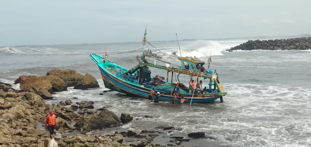 TERSANGKUT: Sebuah kapal tersangkut di atas karang saat akan melaut. (Jumai/ Radar Jember)