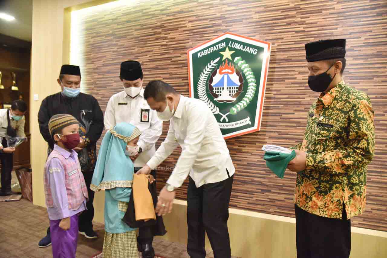 KAPAN MASUK: Bupati Thoriqul Haq ketika menyerahkan bantuan seragam sekolah. Meski seragam gratis dibagikan, tetapi pertemuan tatap muka belum bisa dilaksanakan karena PPKM.   