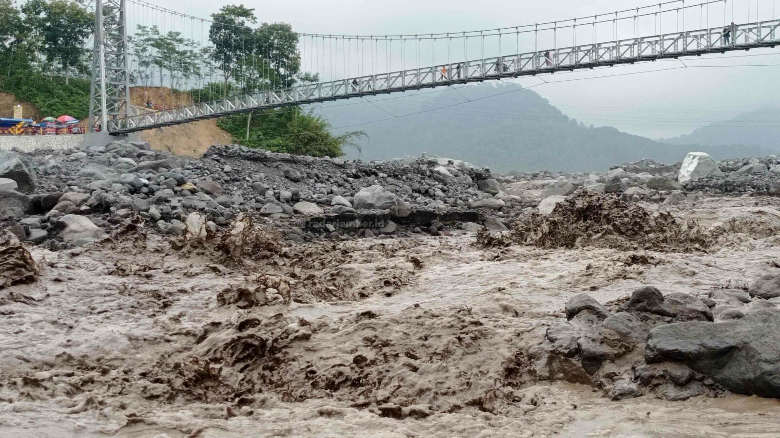 BANJIR: Aliran banjir lahar dingin Gunung Semeru yang melintasi sungai jembatan Kaliregoyo, Sumberwuluh, Candipuro, kemarin.