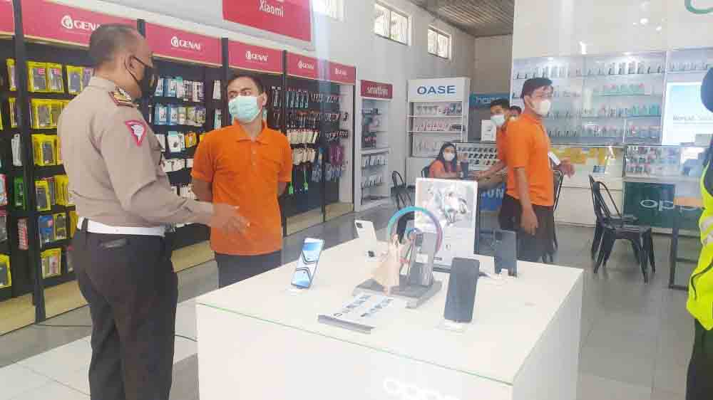 DIIMBAU: Sejumlah petugas kepolisian ketika memberikan arahan kepada salah satu pemilik konter di wilayah kota Bondowoso.