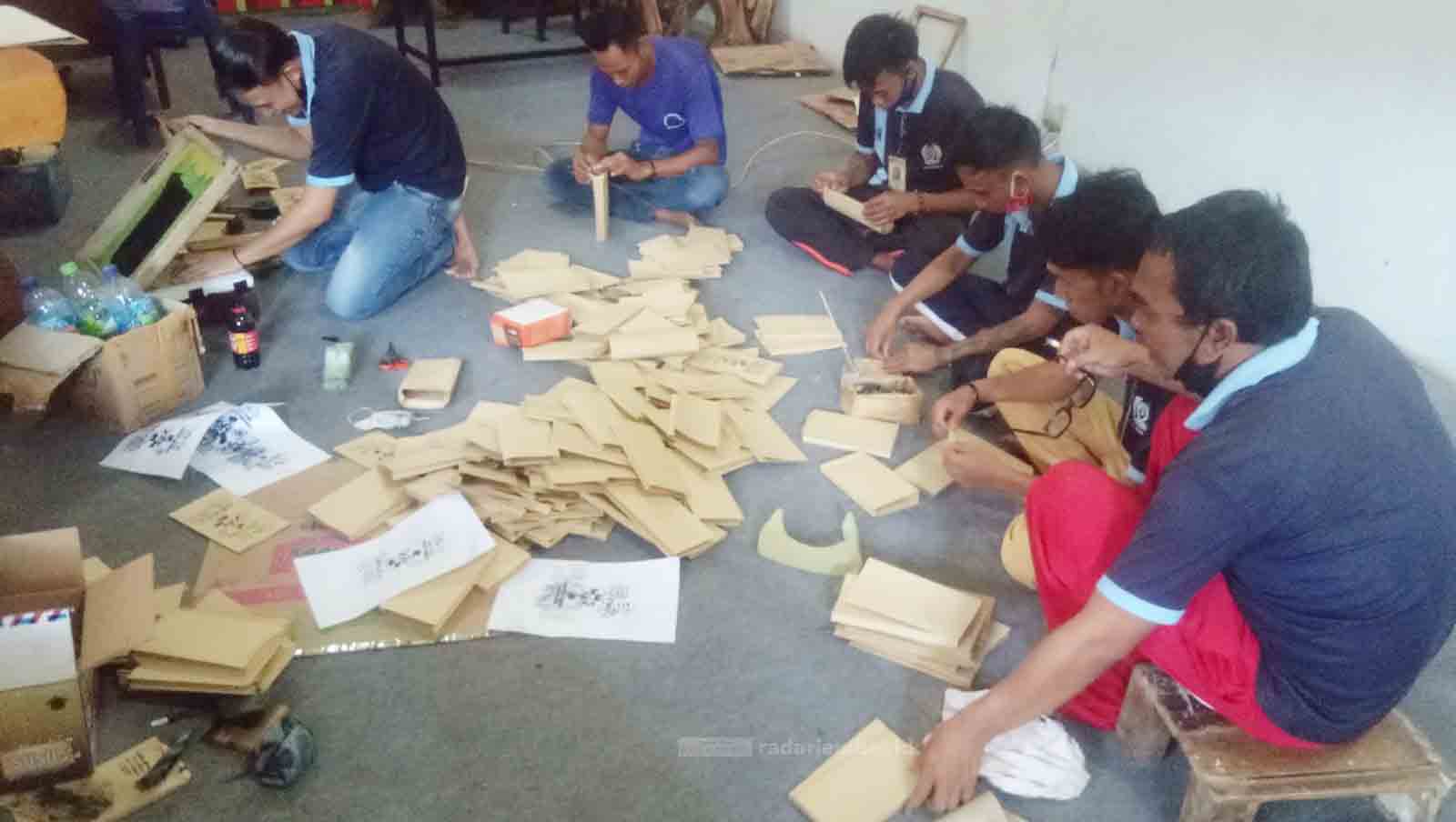 SIBUK BIKIN KEMASAN: Sejumlah warga binaan pemasyarakatan (WBP) Lapas Kelas II B Bondowoso ketika membuat sablon bungkus makanan. Mereka mendapat orderan dalam jumlah banyak.