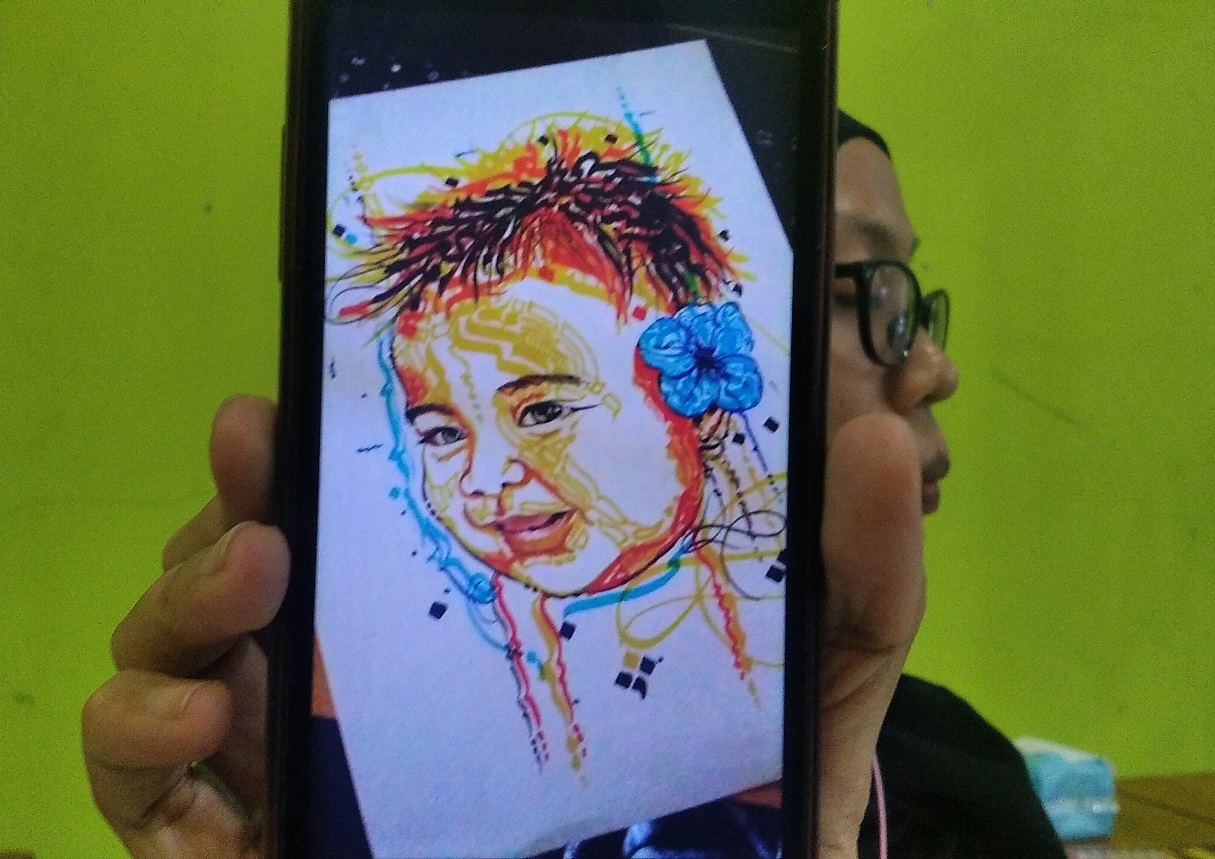 WARNA-WARNI: Seorang seniman menunjukkan karya facegraphy, sebuah jenis kaligrafi baru bagi seniman Jember