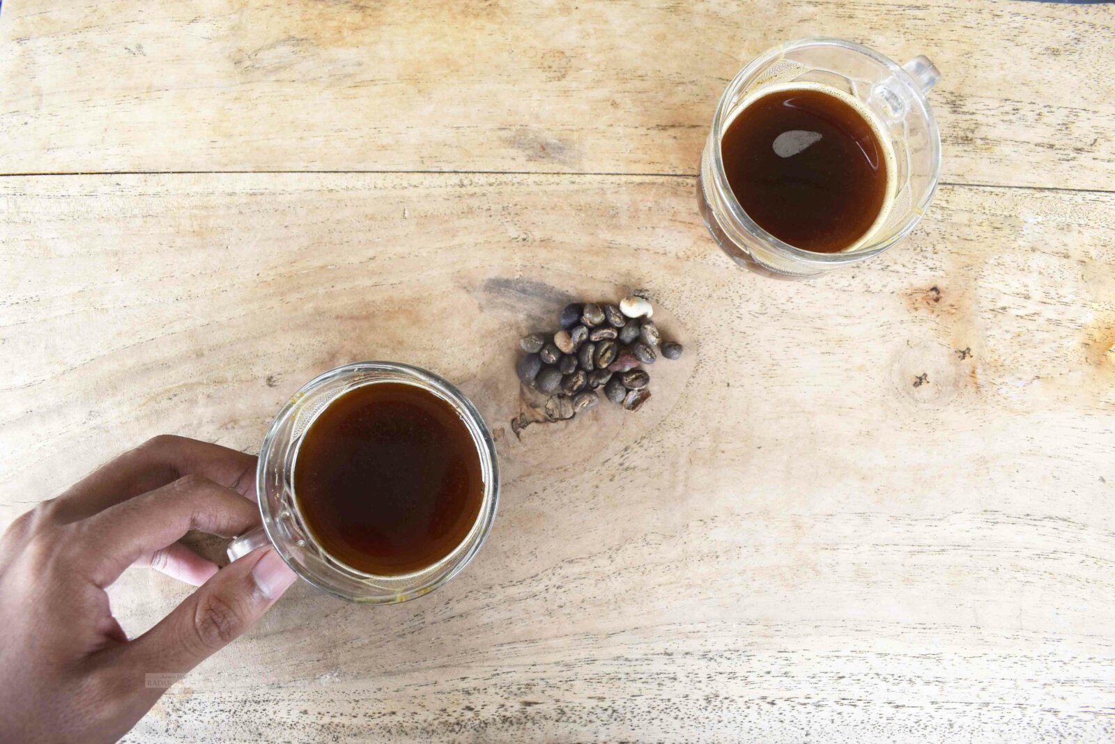 KUALITAS BAGUS: Salah seorang pengusaha kafe ketika menunjukkan biji kopi serta seduhan kopi asli Bondowoso.
