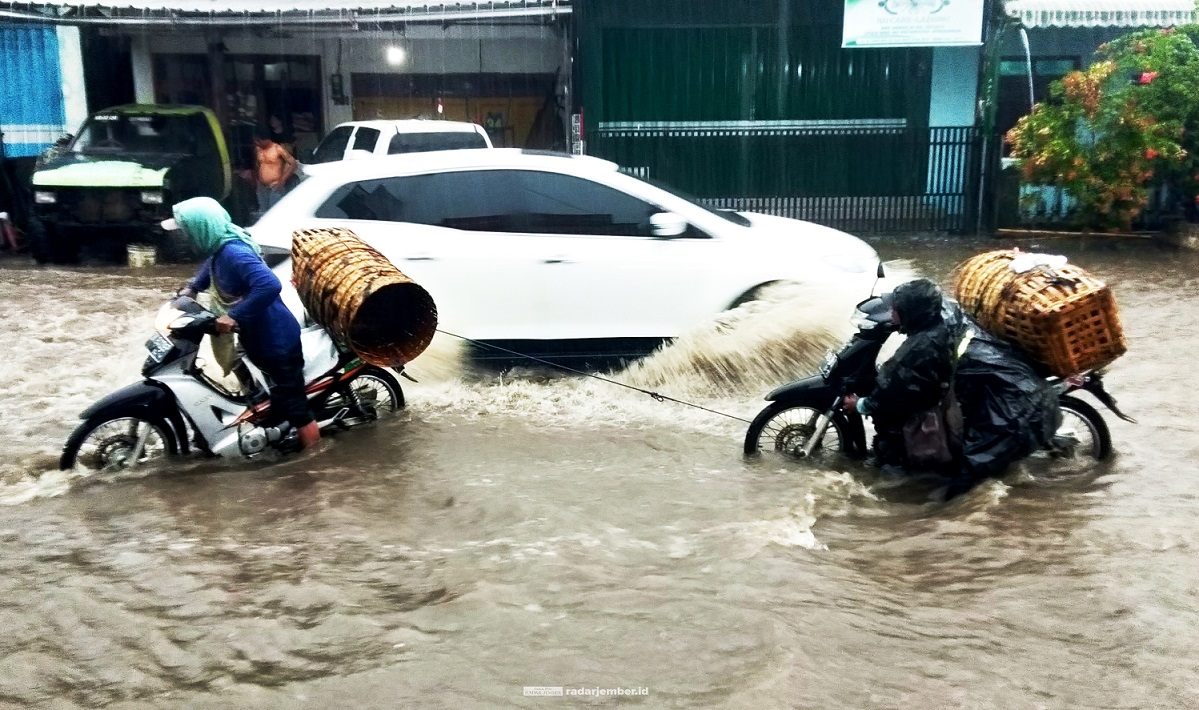 JADI SUNGAI: Jalan raya jurusan Ajung–Ambulu digenangi air dengan ketinggian hingga betis orang dewasa, setelah hujan turun cukup deras, kemarin (13/9) siang.