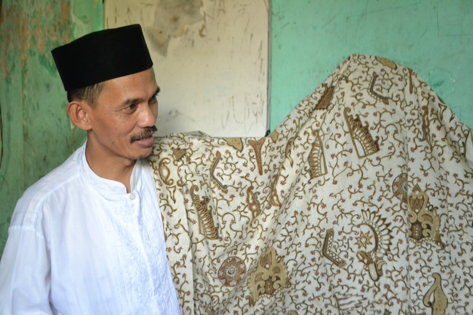 BERNILAI BUDAYA: Salah seorang perajin sedang menunjukkan kain batik produksi Jember. Para perajin menyebut, untuk menentukan motif khas batik Jember butuh campur tangan pemerintah daerah.