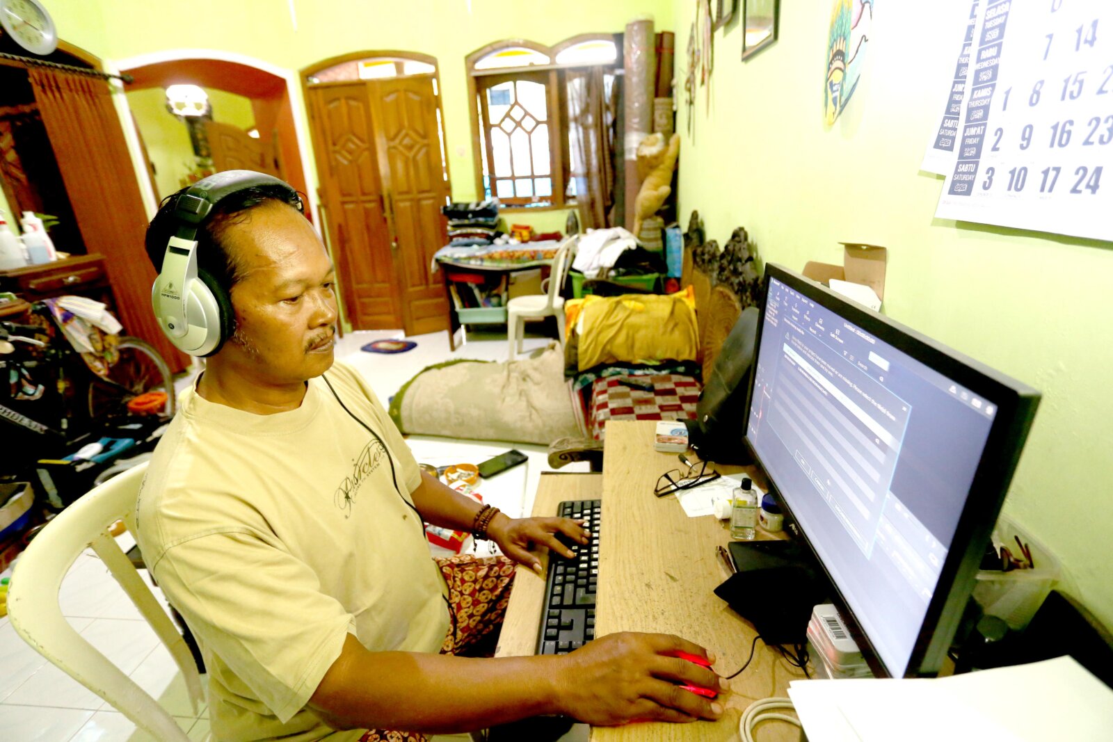 TETAP PRODUKTIF: Supartu atau akrab disapa Kang Partu tengah memproses editing video. Pandemi seperti ini membuat mantan penyiar radio genre campursari tersebut kian produktif memproduksi lagu campursari beserta editing videonya.