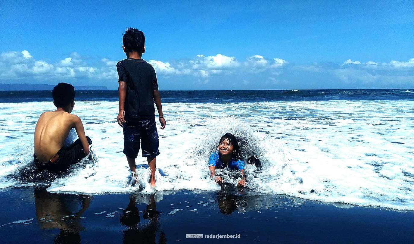 BERMAIN OMBAK: Sejumlah anak mandi di bibir Pantai Paseban, Kecamatan Kencong, beberapa waktu lalu. Meski banyak tempat wisata yang sudah buka, namun jumlah pengunjung masih sepi.