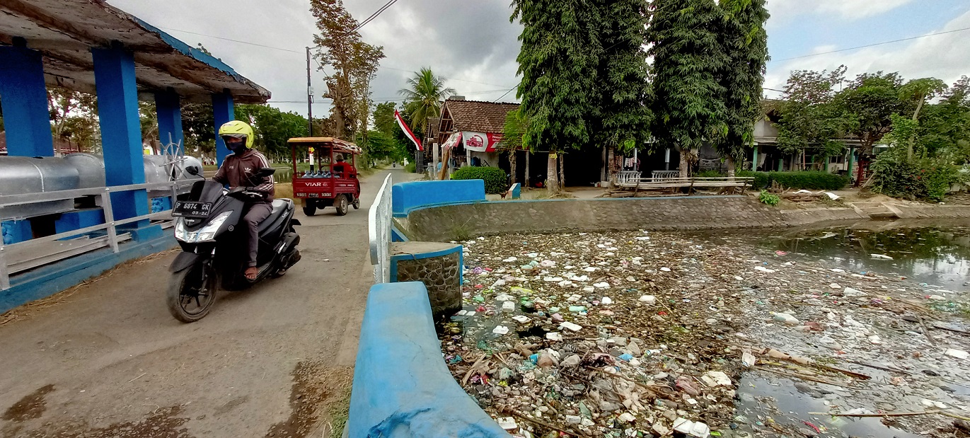 MENYUMBAT DAM: Tumpukan sampah yang membanjiri area pintu air atau dam di Desa Curahmalang, Kecamatan Rambipuji.