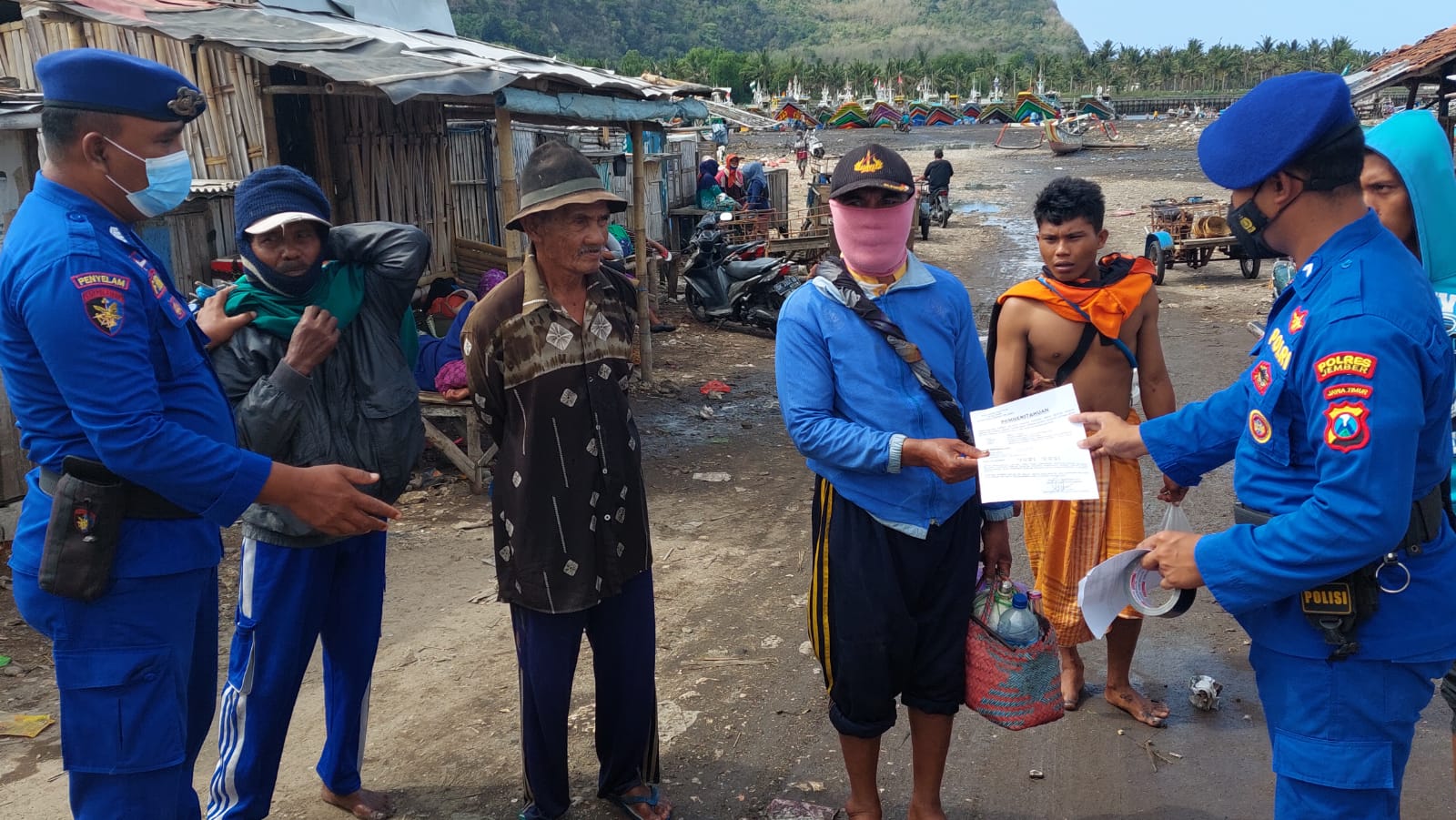 CEGAH BAHAYA: Satpolair Polres Jember di Kecamatan Puger, membagikan selebaran berisi imbauan kepada nelayan. Mereka diminta hati-hati ketika melaut karena di kawasan pesisir Lumajang akan ada latihan menembak.