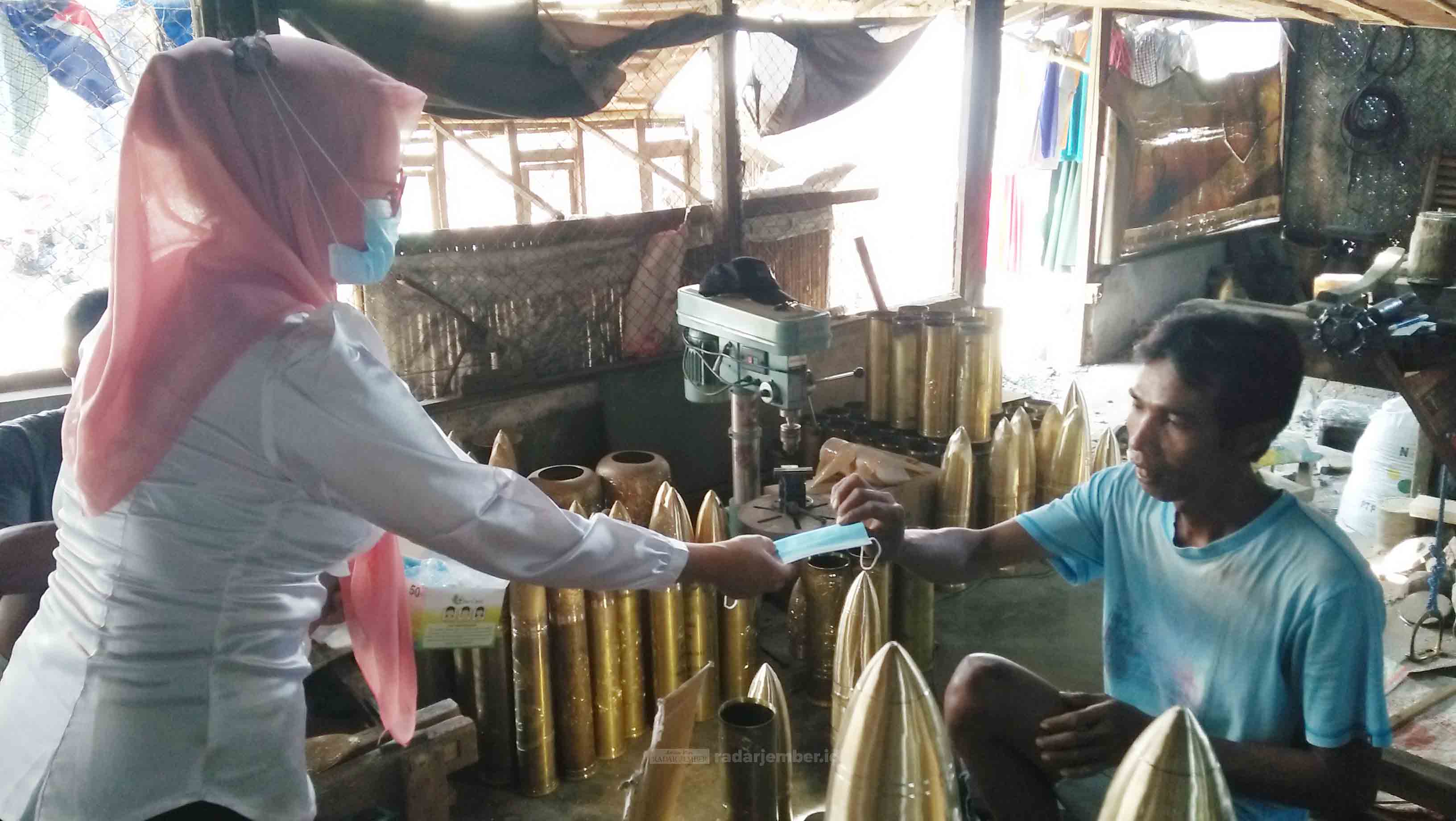 BERIKAN MASKER: Salah seorang tenaga kesehatan (kiri) dari Pondok Kesehatan Desa (Ponkesdes) ketika memberikan masker kepada pekerja kuningan di Desa Cindogo, Tapen, kemarin.