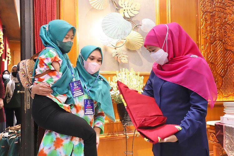 DIGENDONG: Muzayyanah ketika menggendong Siti Rohmatillah, disabilitas asal Desa Jetis, Curahdami, dalam acara Jatim Fair 2021 kemarin di Surabaya. Gubernur Jawa Timur pun kagum atas karyanya.