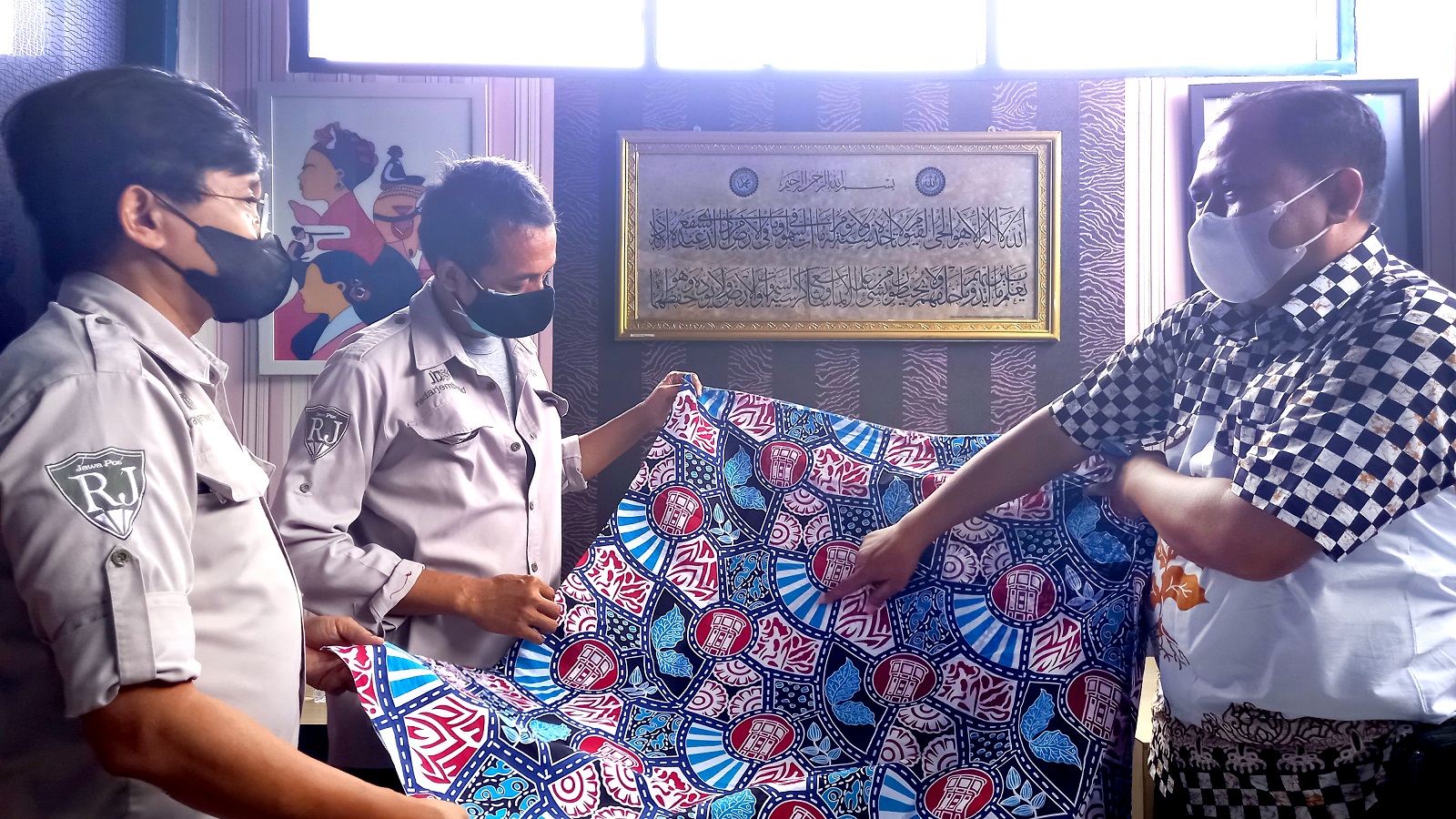 JEMBER BANGET: Dari kiri ke kanan, Direktur Radar Jember Abdul Choliq Baya, GM Radar Jember MS Rasyid, dan pemilik Damas Batik Heri Ferdiansyah menunjukkan motif batik terbarunya yang akan diberikan kepada pemenang lomba.
