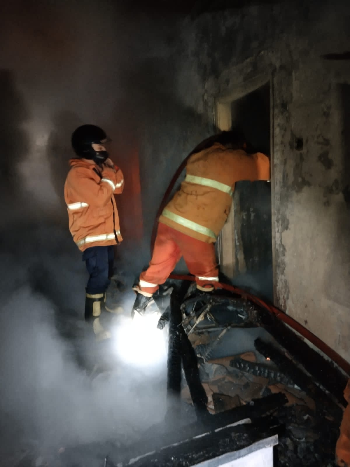 Petugas Damkar memadamkan api di Desa Sumberjati, Kecamatan Silo dini hari.