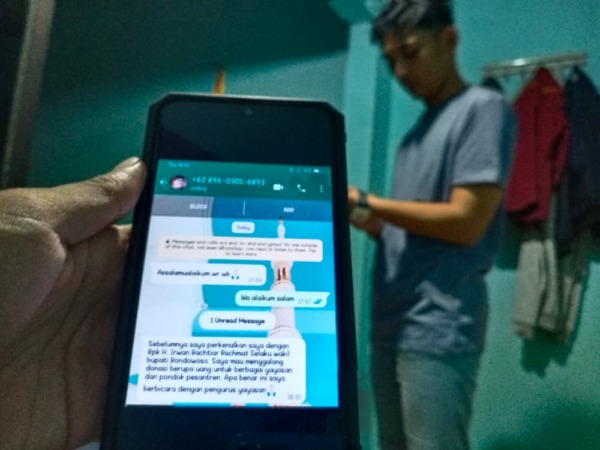 HATI-HATI: Salah seorang warga ketika menunjukan bukti tangkap layar modus penipuan atas nama wakil bupati.