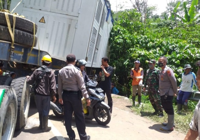 TERPEROSOK: Sebuah truk trailer yang terperosok di Desa Sumberejo mengakibatkan arus lalu lintas terhambat. Akibatnya, Jalur Bondowoso-Ijen sempat lumpuh selama beberapa jam.