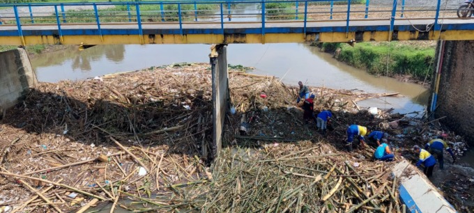 TERSUMBAT: Petugas pengairan membersihkan barongan bambu yang menyumbat Dam Pondokwaluh. Bambu-bambu ini terbawa arus dari hulu saat banjir pada 10 November lalu.