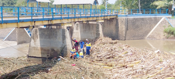 TERSUMBAT: Dam Bendung Pondokwaluh di Desa Wringinagung, Kecamatan Jombang, tersumbat barongan bambu dan potongan kayu. Untuk membersihkan barongan bambu, kayu, serta pohon pisang itu hanya menggunakan tenaga manual alias dikerjakan oleh tenaga manusia