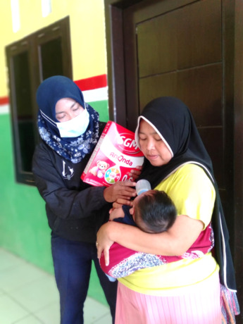 PENCEGAHAN: Salah satu pegawai Kecamatan Sukorambi mengawal pembagian PMT di Desa Karangpring, kemarin (19/12).