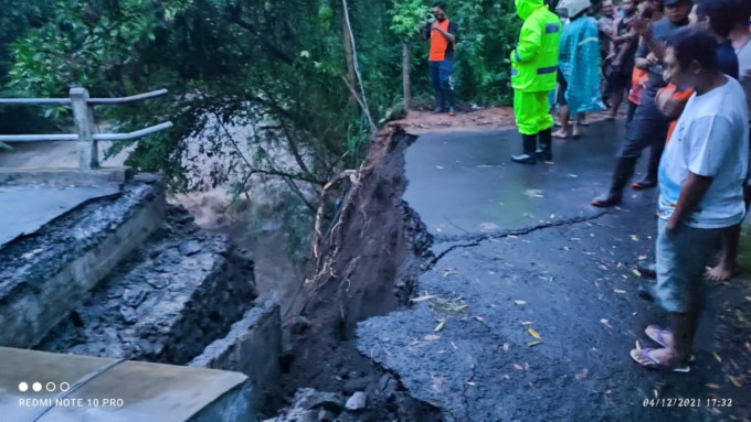 RUSAK: Petugas ketika memantau jembatan yang rusak akibat diterjang banjir.