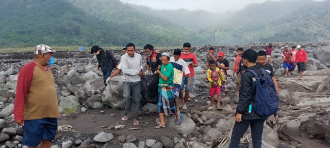 EVAKUASI: Warga dan tim relawan saat mengevakuasi jasad jenis perempuan yang tertimbun abu vulkanik Gunung Semeru, pagi ini. (JUMAI/RADAR JEMBER)