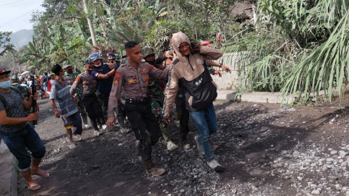 PROSES EVAKUASI: Tim SAR bersama polisi dan TNI mengangkat jenazah pencari rumput yang tertimbun lahar dingin erupsi Gunung Semeru.