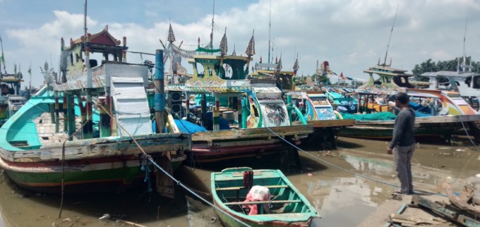 ABSEN MELAUT: Seorang nelayan memeriksa perahunya yang terparkir di area tambatan perahu di kawasan Dermaga Puger. Nelayan banyak yang tidak melaut sementara waktu akibat santernya isu tsunami.