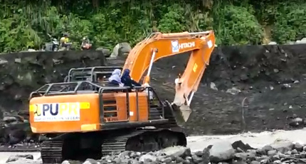 PERJUANGAN: Tangkapan gambar video amatir tenaga kesehatan yang menyeberangi Sungai Leprak menggunakan alat berat jenis excavator, kemarin pagi.