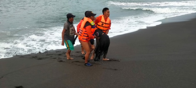 PROSES EVAKUASI: Tim penolong saat mengevakuasi jenazah korban tenggelam di Pantai Payangan.