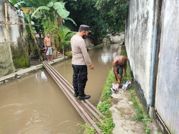 RESPONS LAPORAN: Anggota Polsek Balung mendatangi lokasi penemuan tubuh korban. Ditengarai, dua bocah yang ditemukan meninggal tersebut hanyut saat mandi di saluran irigasi Desa Balung Lor, Kecamatan Balung, Jember.