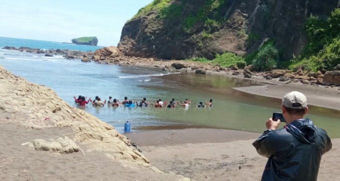 SEPERTI LAGI SEMEDI: Sekelompok orang berendam bersama di pinggir Pantai Watu Ulo. Mereka berasal dari Nganjuk dan sedang melakukan ritual di tempat itu.