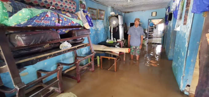 BANJIR: Hariyanto saat mengamankan barang-barang di rumahnya ketika banjir mulai datang. Banjir selutut orang dewasa ini sudah terjadi dua kali selama tahun ini.