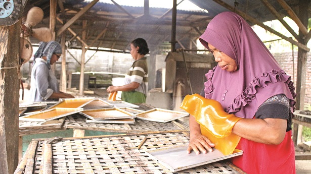 DIJEMUR: Salah seorang pengusaha kerupuk, Yu Minah, ketika menjemur kerupuk hasil produksinya dengan dibantu sejumlah karyawan. Di tengah keterbatasan minyak, dia tetap mempertahankan usahanya.