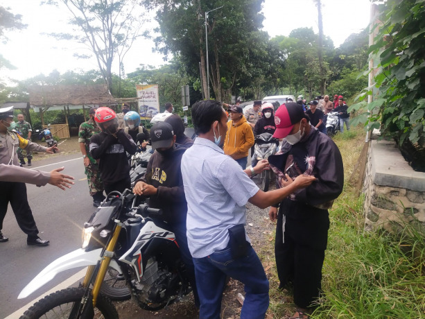 SIAGA: Polisi menggeledah salah satu anggota perguruan silat yang akan ke Banyuwangi. Petugas melakukan penyekatan di jalur Gumitir untuk mencegah pergerakan massa ke kabupaten tetangga.