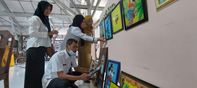 EKSENTRIK: Sejumlah guru melihat hasil kreasi siswa yang disuguhkan dalam pameran seni rupa. Acara itu berlangsung di Aula SMPN 1 Jember, Senin (21/3).