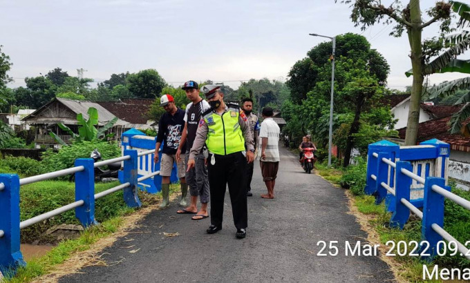 CARI BUKTI: Petugas kepolisian melakukan olah TKP di areal jembatan Dusun Kedung Lengkong, Desa Menampu, Kecamatan Gumukmas, Jember. Akibat tabrak lari ini, seorang petani meninggal.