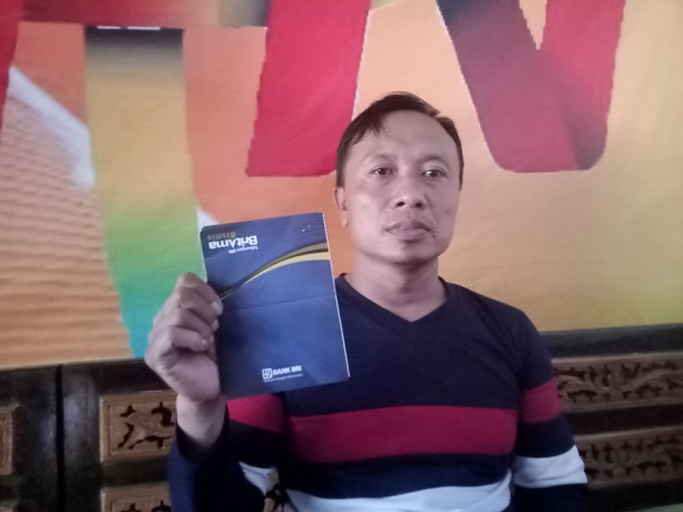 BERI KETERANGAN: Ali Mu’afan Rohim ketika menunjukkan rekening koran tabungannya setelah terjadi transaksi selama tiga kali yang meludeskan uang ratusan juta.