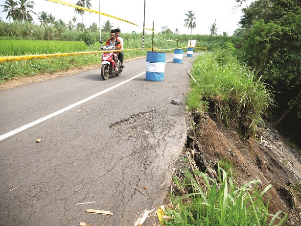 TERGERUS: Kondisi plengsengan sungai Dusun Curah Mayit, Desa/Kecamatan Randuagung. Hampir sebulan, plengsengan yang longsor dan membahayakan pengendara yang melintas ini masih ini belum tersentuh perbaikan.