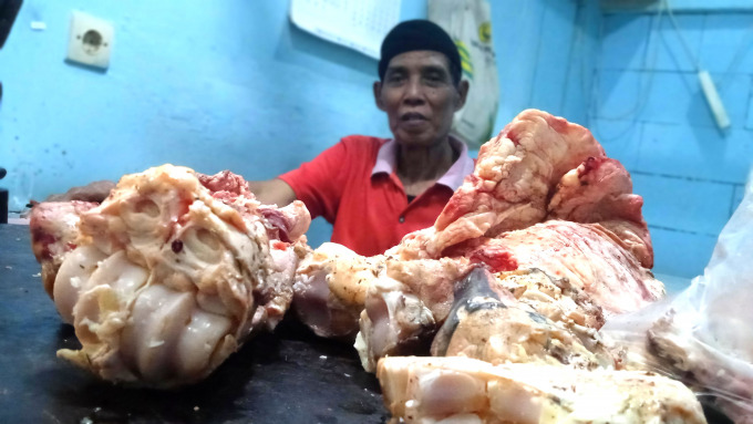 BAKAL NAIK: Rais, salah satu pedagang, ketika menjual daging sapi di Pasar Induk Bondowoso, kemarin. Pedagang kelahiran Situbondo ini mengaku, meski harga daging bakal naik menjelang Lebaran, kebutuhan pembeli juga akan meningkat.