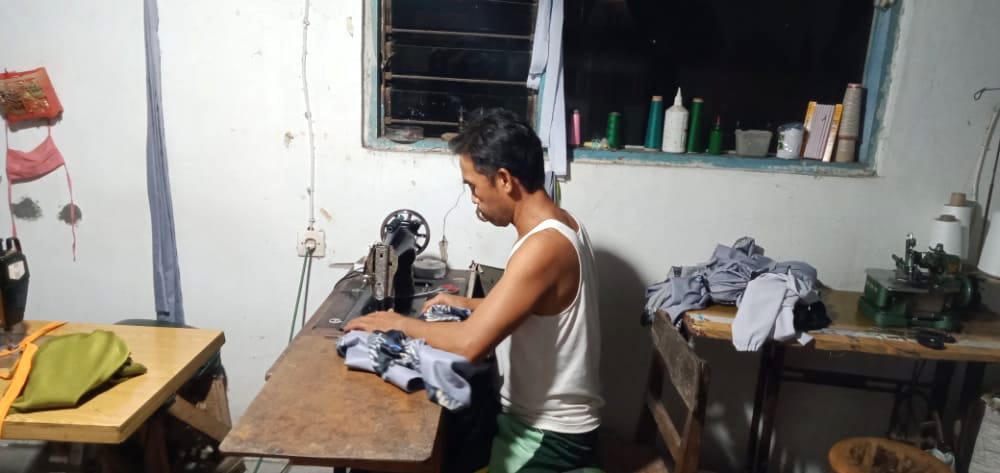 TEKUN: Murtilah saat mengerjakan pesanan baju pelanggan.